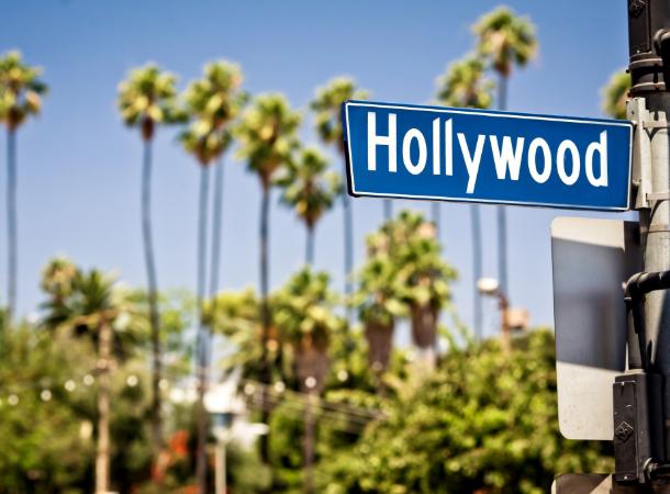 A blue street sign on the corner of an intersection in Los Angeles reads "Hollywood"