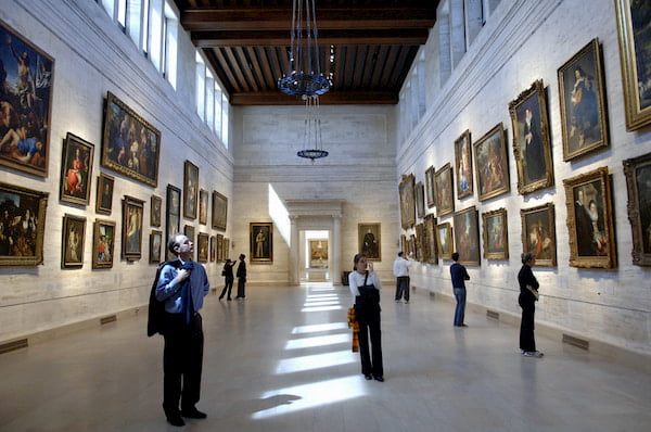 Tourists observing works of art in a gallery