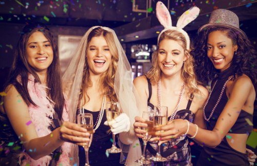 a bride and her bridesmaids toast at a bachelorette party