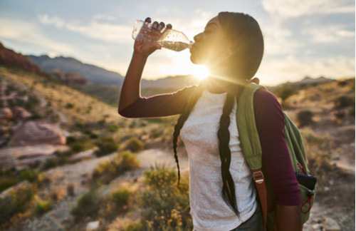 woman taking a water break while hiking