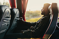 A bus passenger relaxes in a plush leather seat