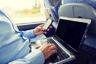 man working on a computer aboard a charter bus