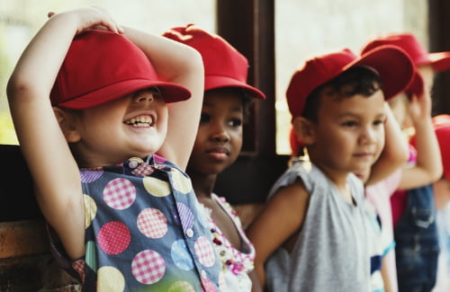 kids wearing baseball hats and smiling
