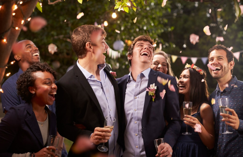 A couple celebrate at their wedding reception surrounded by loved ones
