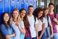 students line up in front of their blue lockers in a hallway
