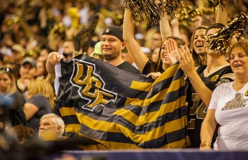 A group of UCF fans in the bleachers cheering on the football team