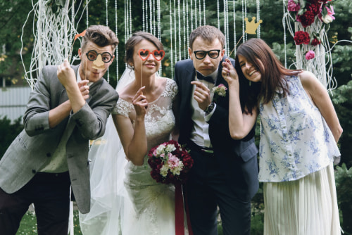 wedding guests pose for a picture with props