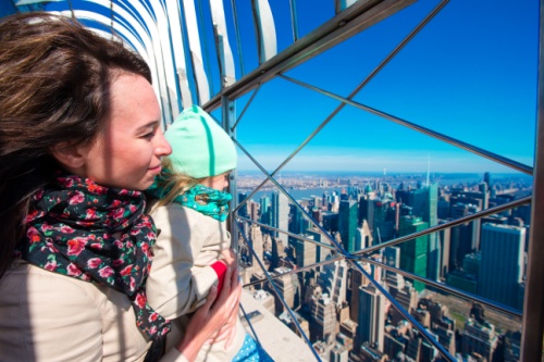 a woman and her daughter enjoy the view from the 86th floor observation deck