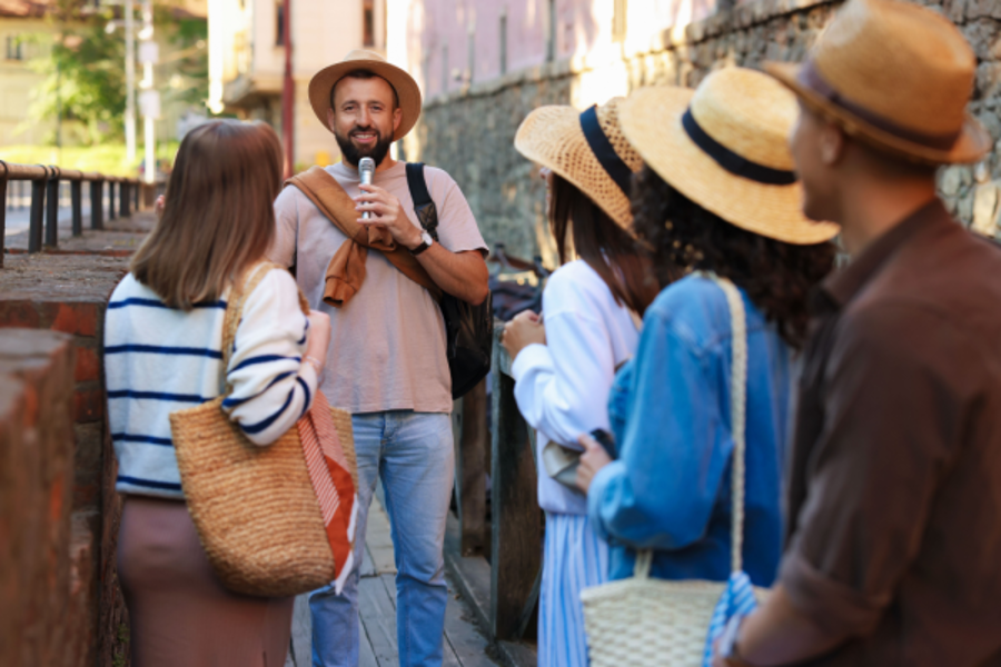 a tour guide explains a landmark with a microphone while a group listens