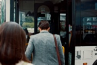 employees stand in line to board their charter bus