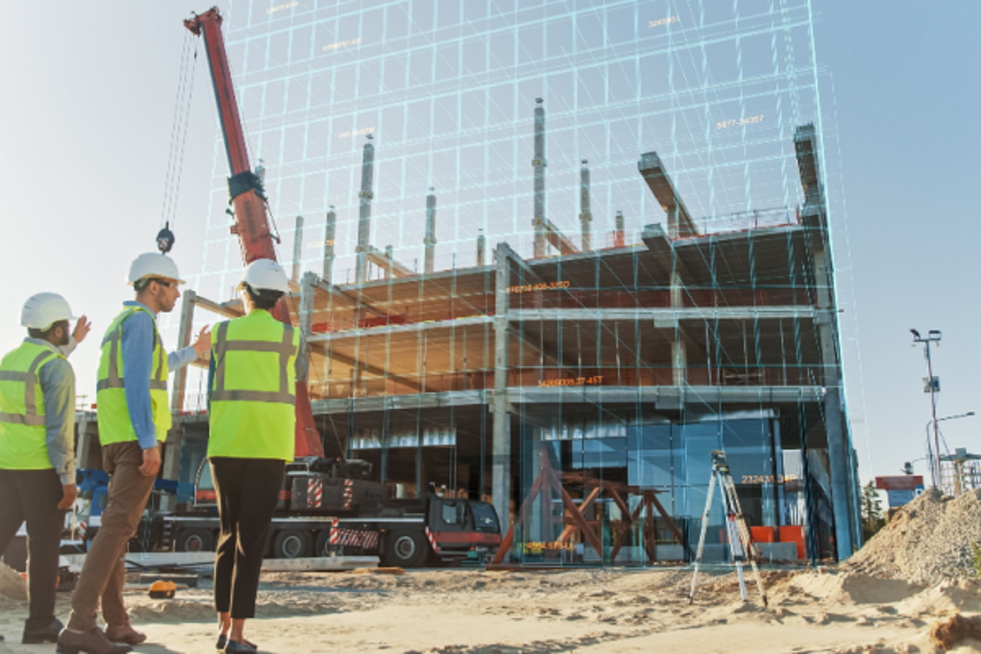 visitors wearing hard hats approach an office building under construction