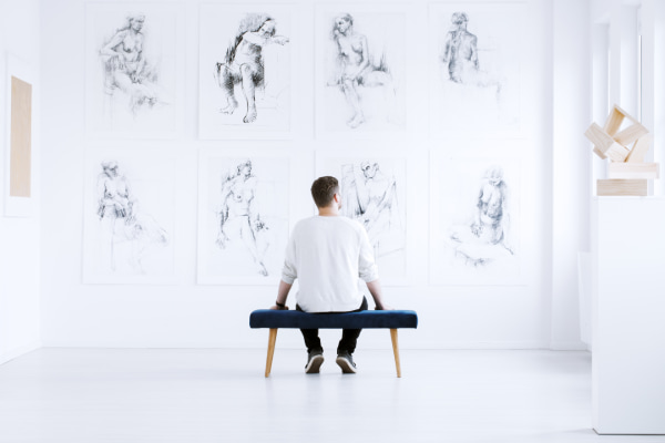 a man admires drawings in an art gallery