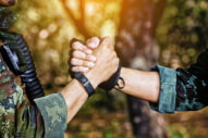 two soldiers grasp hands
